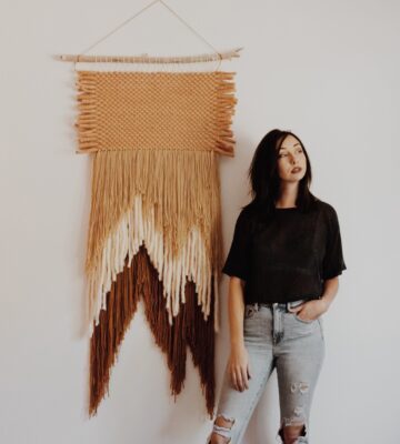 Woman in front of tapestry