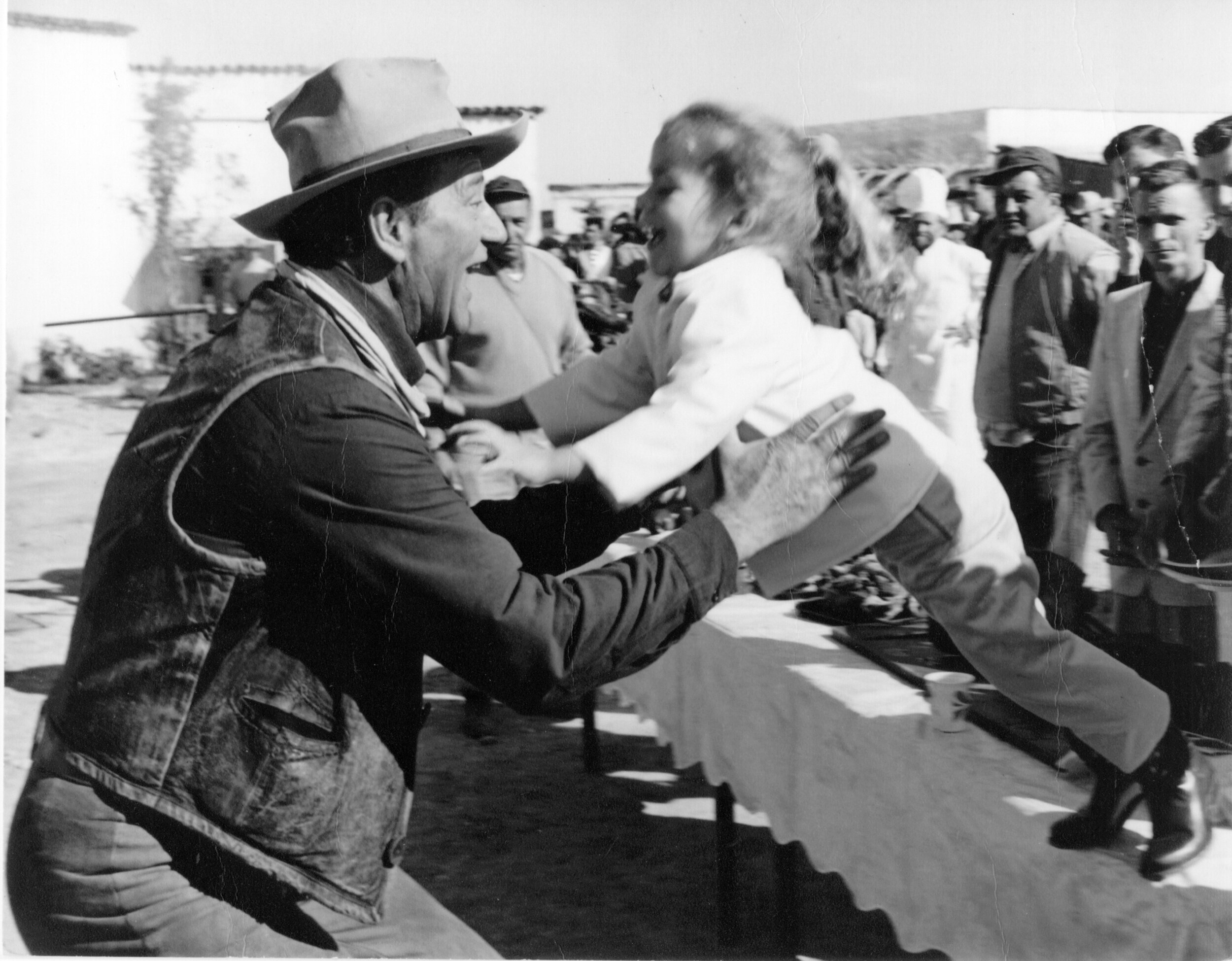 John Wayne catches his daughter on the set of The Alamo.