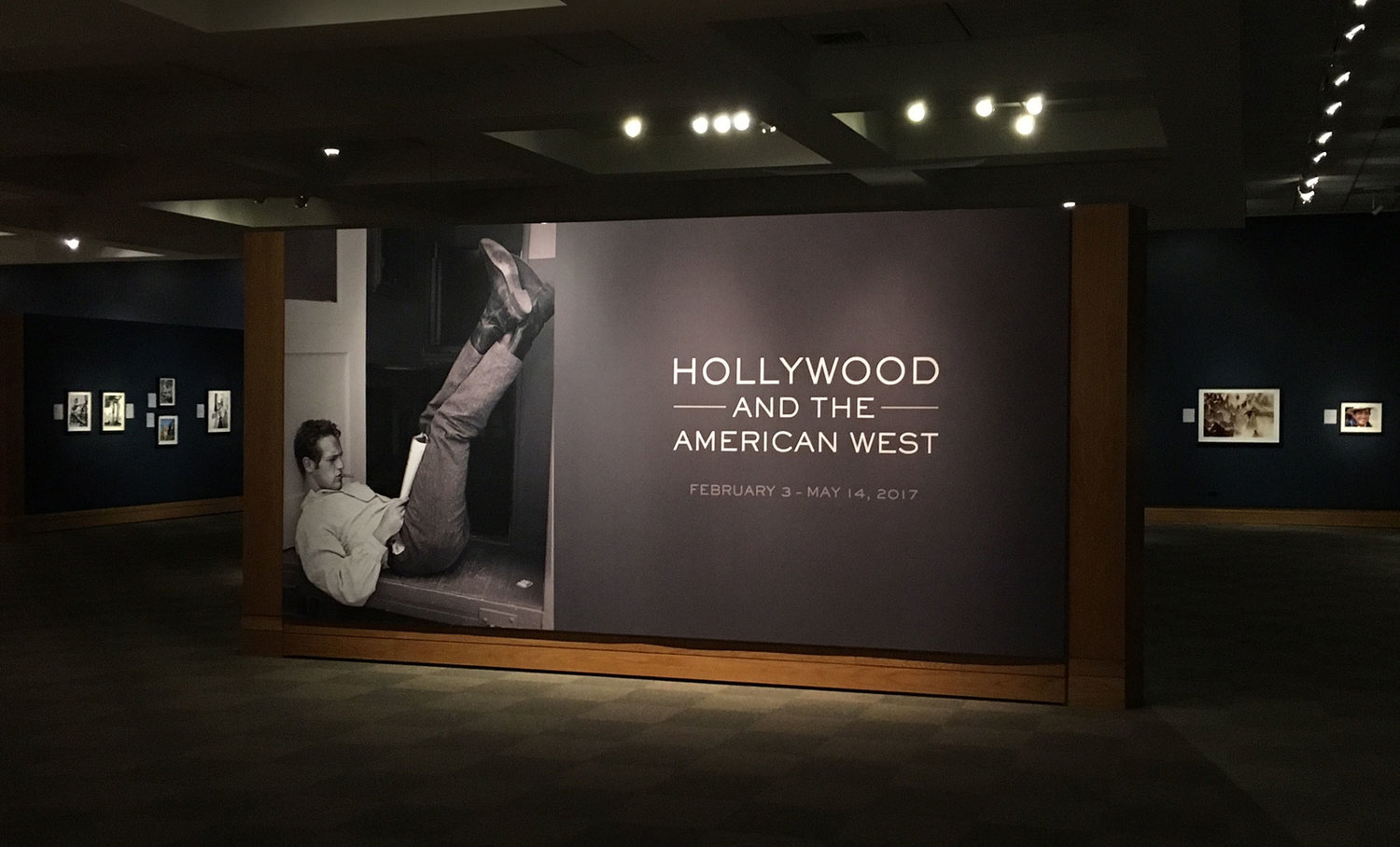 The entrance to the exhibit features an image of Paul Newman reading the script for The Left Handed Gun (1958) in front of his dressing room on the Warner Bros. lot in Burbank, California. Photo courtesy of John Wayne Enterprises