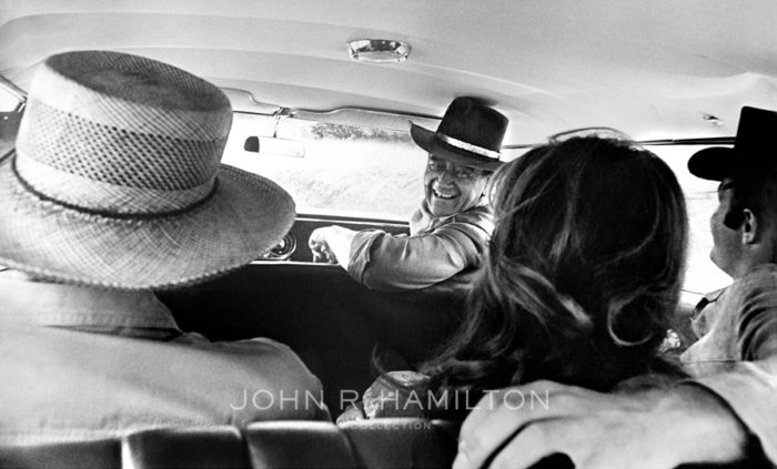 John Wayne, Howard Hawks, Charlene Holt and James Caan traveling between takes while filming El Dorado (1966). Image by John R. Hamilton, courtesy of John Wayne Enterprises