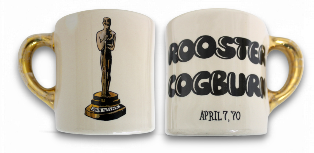 Original 'Rooster Cogburn' gold handle mug celebrating John Wayne's first Oscar win, featuring elegant design and 12K gold detailing.